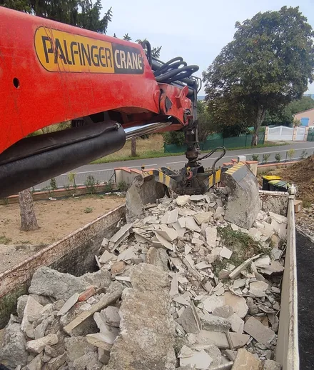 Camion grue en action pour le chargement de gravats de chantier à Toulouse